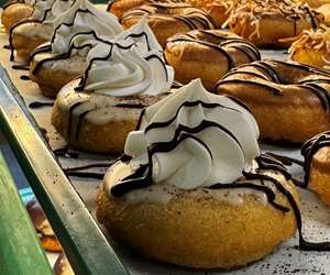 Cake donut topped with espresso icing and whipped topping with chocolate drizzle